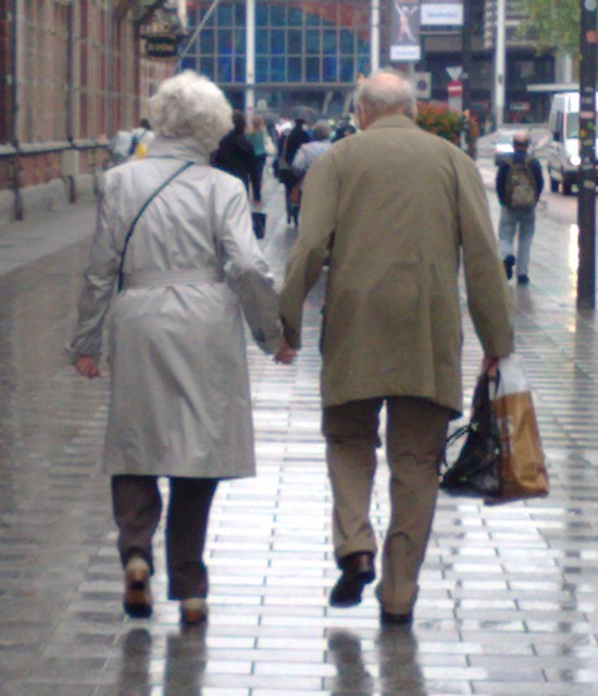 elderly couple holding hands